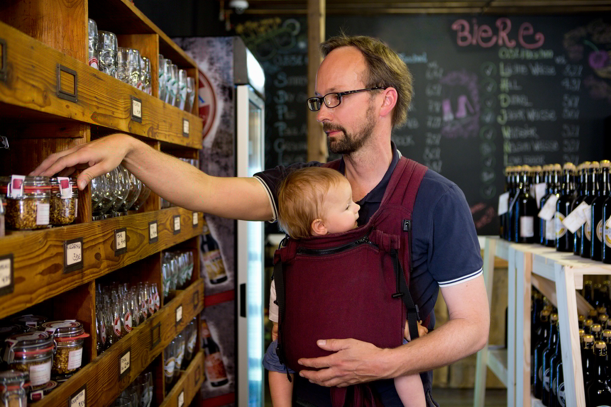 Father with baby daughter looking at jars in shop