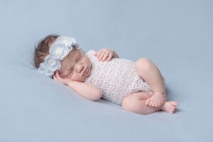 Baby girl in a white dress sleeping